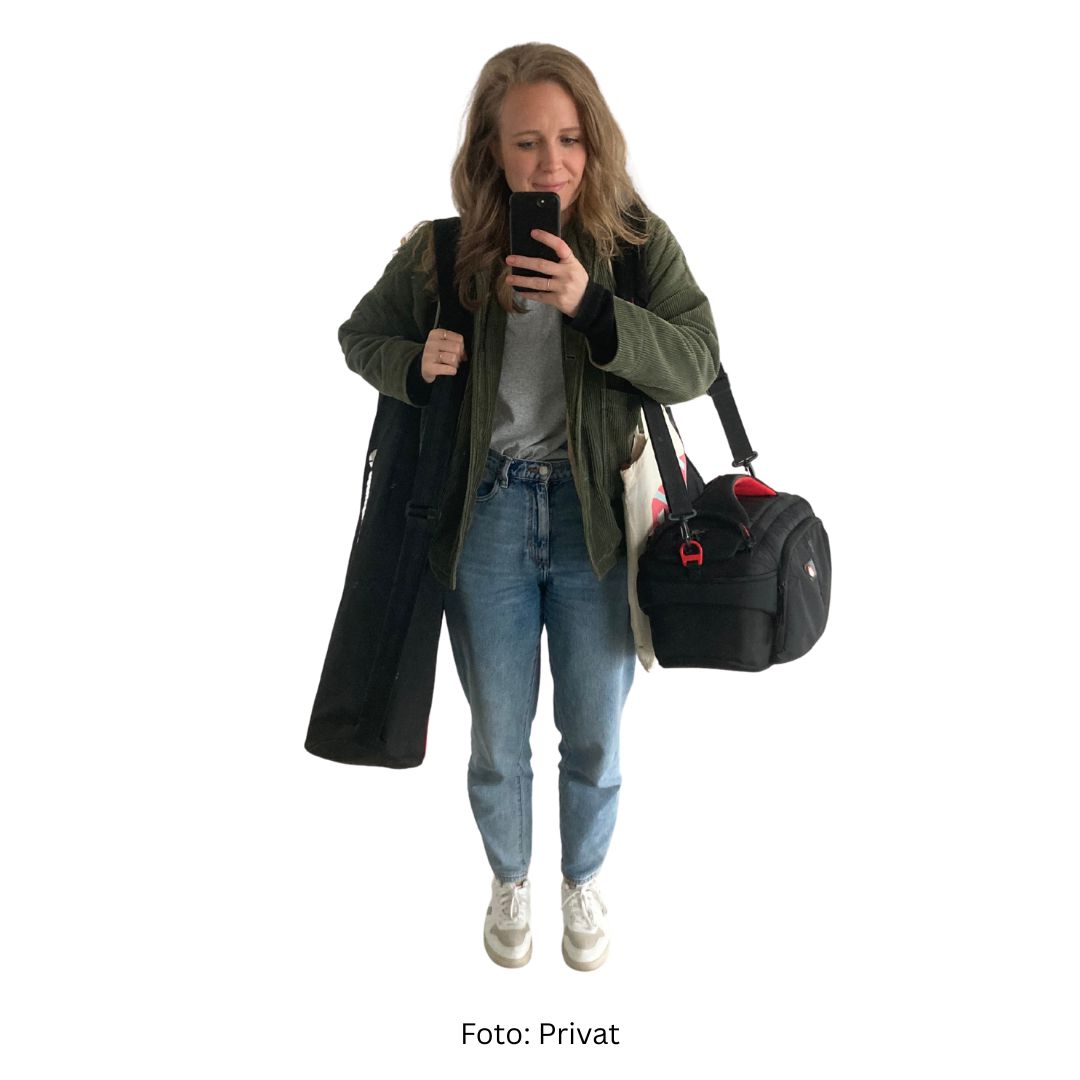 Das Foto ist ein Selfie. Es zeigt Wissensnah-Redakteurin Magdalena mit zwei großen Taschen. Darin ist ein Stativ und eine Kamera.