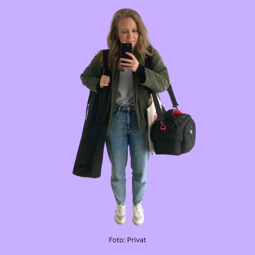 Das Bild ist ein Selfie. Es zeigt Wissensnah-Redakteurin Magdalena Schwarz von vorne. Sie trägt zwei schwarze Taschen, in denen ein Stativ und eine Kamera sind. Sie trägt eine grüne kurze Jacke, helle Jeans und weiße Sneaker.