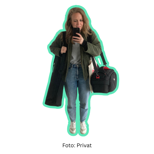 Das Bild ist ein Selfie. Es zeigt Wissensnah-Redakteurin Magdalena Schwarz von vorne. Sie trägt zwei schwarze Taschen, in denen ein Stativ und eine Kamera sind. Sie trägt eine grüne kurze Jacke, helle Jeans und weiße Sneaker.