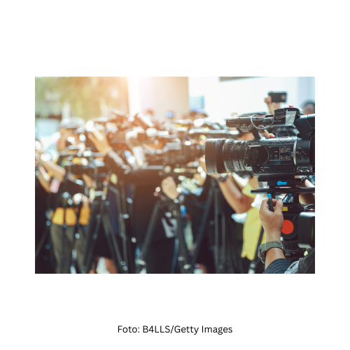 eine Gruppe an Reporter:innen mit Kameras und Mikrofonen